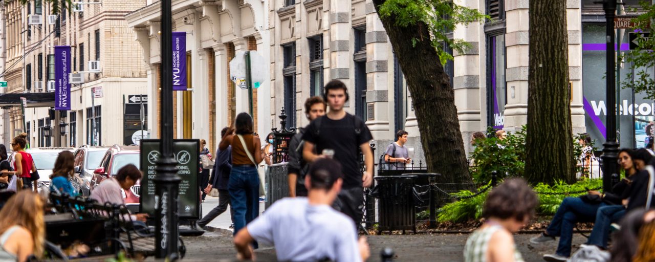 Students mill about a busy street near NYU SPS.