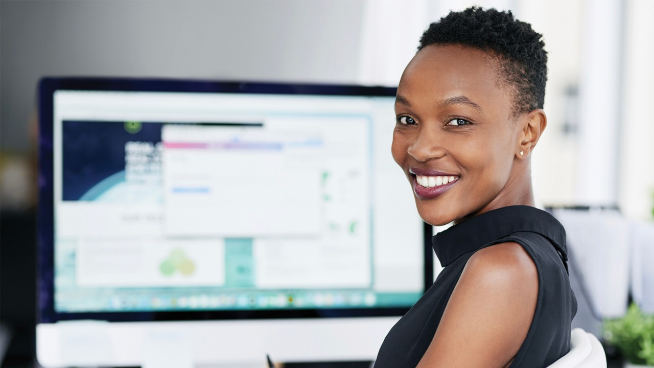 Smiling professional in front of monitor screen